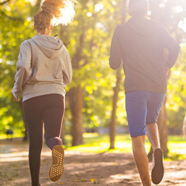 Zwei Personen joggen im Park, Ansicht von hinten