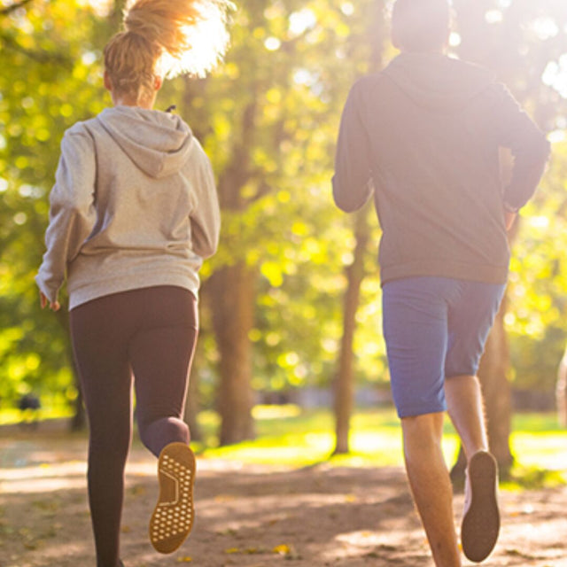 Due persone riprese da dietro fanno jogging nel parco